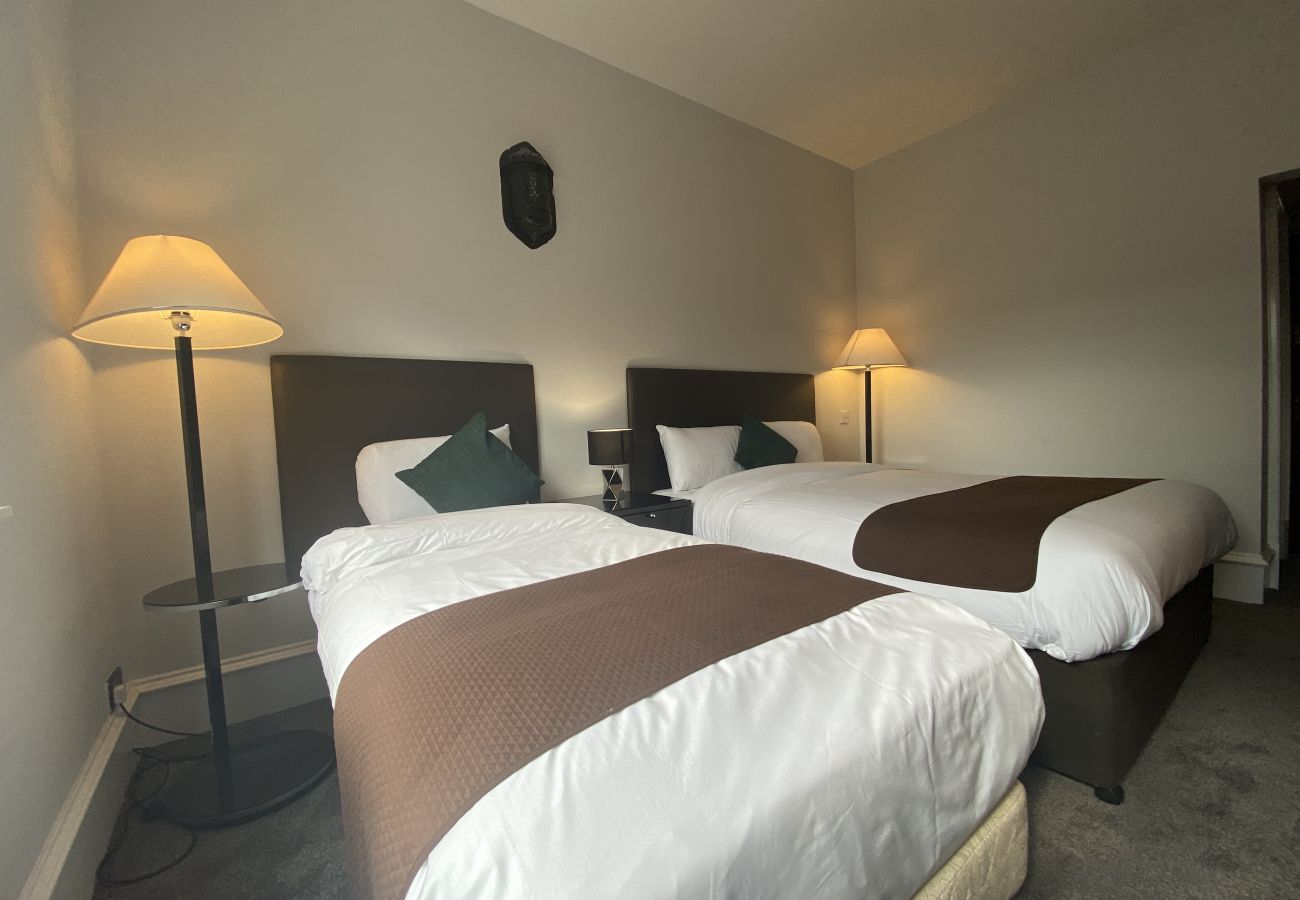 Cozy twin bedroom featuring stylish furniture and decor.